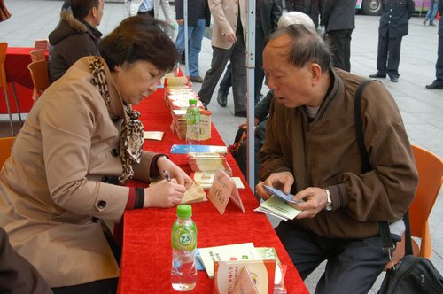 图六：老人在咨询相关的申请登记手续