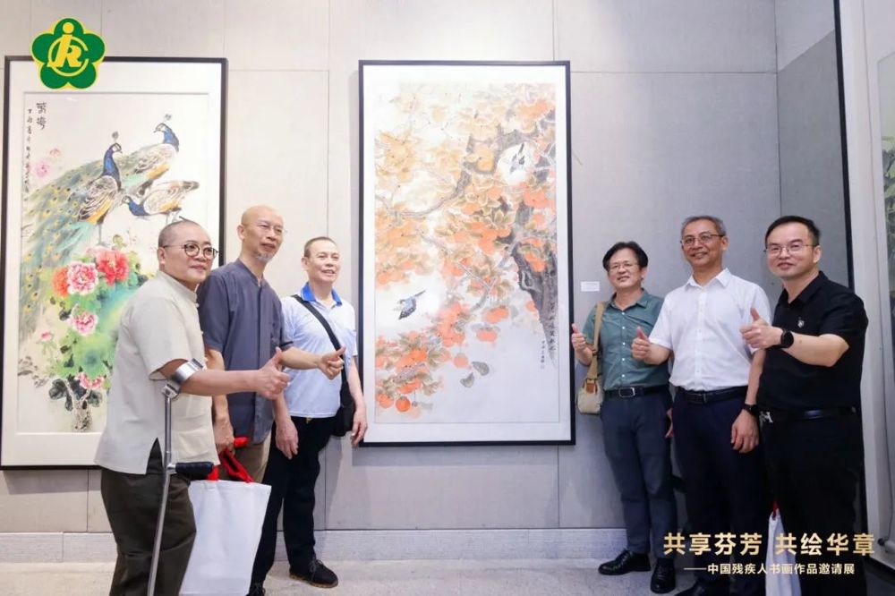 广东省残疾人联合会副理事长柯沫夫、广州市美术家协会主席刘思东等艺术家与参展作者合影