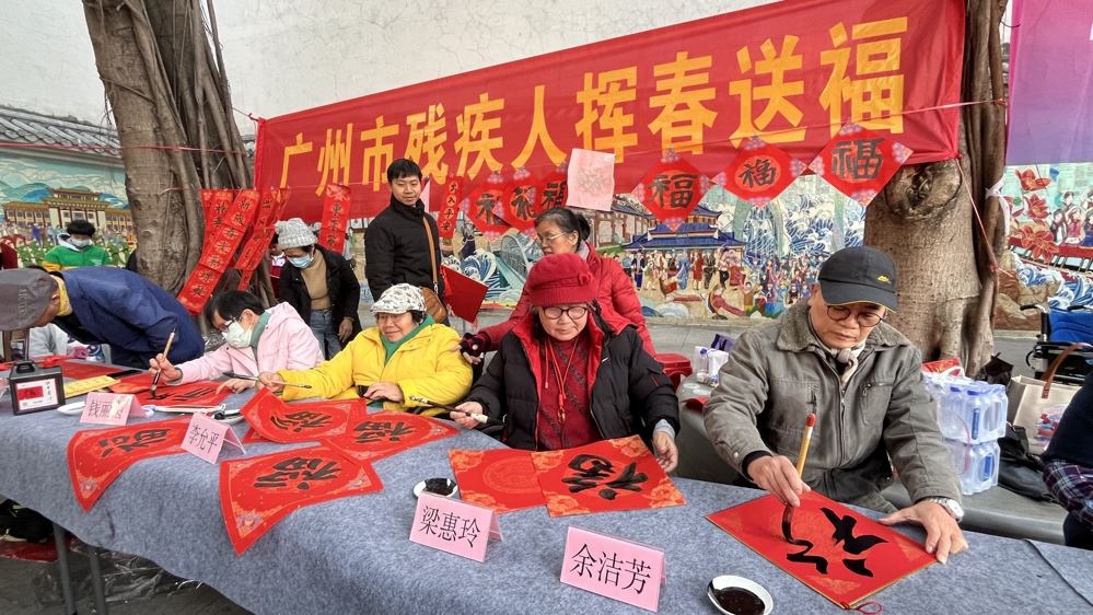 广州市美术家协会温健荣（右一）现场写福